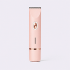 A sleek, handheld electric hair trimmer in a pastel pink color with rose gold metallic accents, shown vertically against a light gray background.